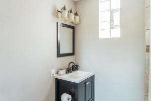 une salle de bain avec un lavabo et un miroir dans l'établissement Spacious 2BR Apartment near Airport - Central Charming, à Dunning 45 autres photos