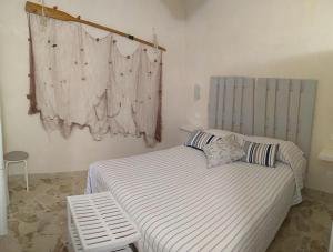 a bedroom with a bed and a chair and curtains at F&L house in Polignano a Mare