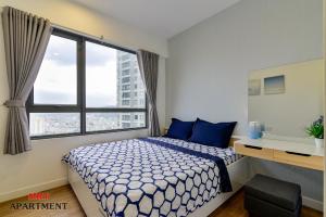 a bedroom with a bed with blue pillows and a window at MRT Apartment In Masteri Thao Dien in Ho Chi Minh City +116 photos
