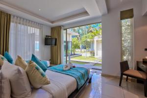 a bedroom with a bed and a large window at La Lagune in Laem Set Beach
