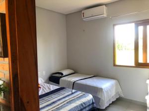 En eller flere senge i et værelse på Recanto da Barra Chalé