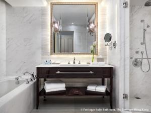 a bathroom with a sink and a tub and a mirror at The Pottinger Hong Kong in Hong Kong