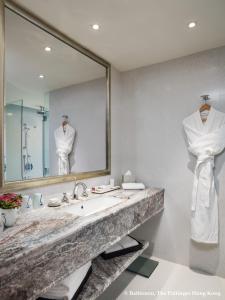 uma casa de banho com um lavatório e um espelho grande em The Pottinger Hong Kong em Hong Kong