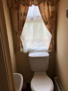 a small bathroom with a toilet and a window at 62 Glenfinart Caravan Park in Dunoon