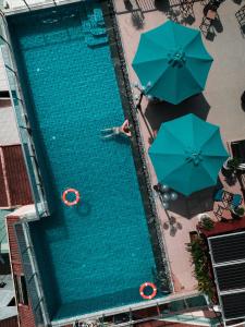 an overhead view of a swimming pool with umbrellas at Uptown Hoi An Hotel & Spa in Hoi An