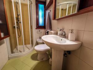 un bagno con lavandino, WC e doccia di Calle del Palazzo a Grado Altre 10 foto
