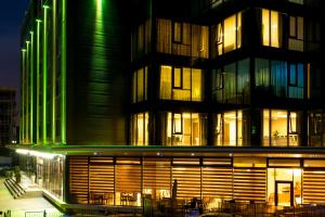 un edificio con luces verdes por la noche en West City Hotel, en Cluj-Napoca