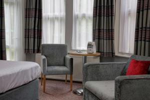 a bedroom with a bed and a chair and a couch at Linton Lodge a BW Signature Collection Hotel in Oxford