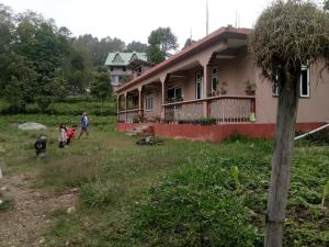 a family walking in front of a house at Kamala Homestay - Manyedara in Aritar