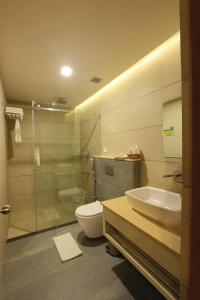 a bathroom with a toilet and a sink and a shower at The River Retreat Heritage Ayurvedic Resort in Shoranūr