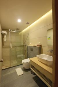 Un baño con inodoro, lavabo y ducha. en The River Retreat Heritage Ayurvedic Resort, en Shoranūr