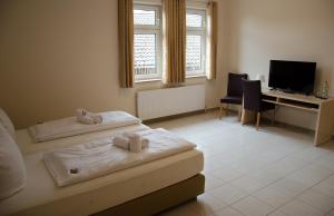 a bedroom with two beds and a desk with a computer at Kraichtaler Hof in Kraichtal