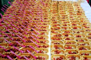 una fila di vassoi di alimenti con ciliegie di Coorg Adventures Tent Stay AND SPA a Kushalnagar