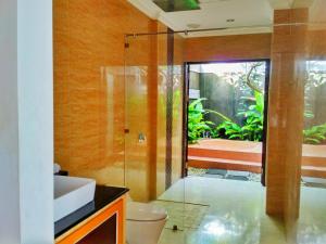 a bathroom with a shower and a toilet and a sink at Amelle Villas & Residences Canggu in Canggu