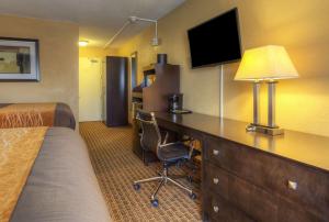 a hotel room with a bed and a desk with a computer at Quality Inn & Suites in Chattanooga