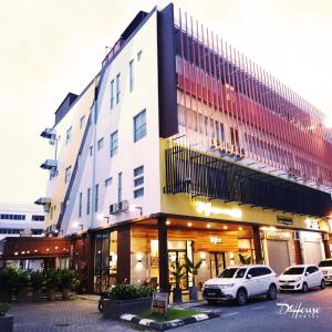 um edifício com carros estacionados em frente em De House Hotel em Sibu