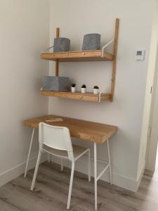 a desk with a chair next to a wall with shelves at Apto Comfortable en María Pita, Centro Ciudad in A Coruña