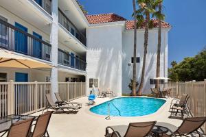 a swimming pool in front of a building with chairs at Comfort Inn Encinitas Near Legoland in Encinitas