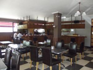 a restaurant with tables and chairs and a bar at Hotel San Blas in Abadiano Celayeta +8 photos