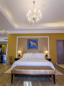 a bedroom with a large bed and a chandelier at Phoenicia Boutique Hotel - Adults Only in Mamaia Nord