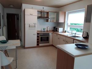 a kitchen with a white refrigerator and a stove top oven at Ferienwohnung Hans in Lindenfels