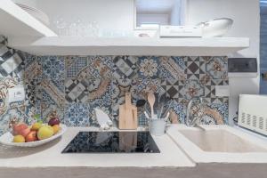 a kitchen with a sink and a bowl of fruit at Azzurro Come Te - Ostuni in Ostuni