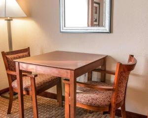 a wooden table with two chairs and a mirror at Quality Inn Near Interstate I94 in New Buffalo
