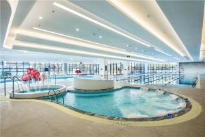 资阳资阳鼎晟泓府豪生大酒店 的大型客房,设有大型游泳池,位于大楼内