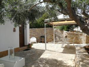 een patio met een parasol en een tafel en stoelen bij Villa Rossana in Scopello
