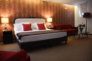 Habitación de hotel con cama y silla roja en Hotel Clara Luna, en Xalapa