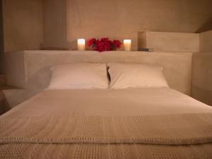 a white bed with two candles on top of it at Cheviot Place Guest House in Cape Town