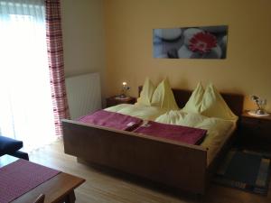 a bedroom with a bed with pillows on it at Tischnerhof Appartements in Bad Kleinkirchheim