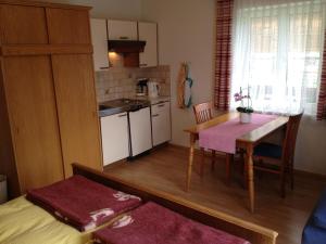 a small kitchen with a table and a dining room at Tischnerhof Appartements in Bad Kleinkirchheim