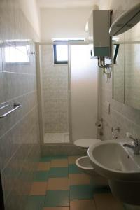 bagno con 2 servizi igienici, lavandino e doccia di Hotel Kennedy a Metaponto