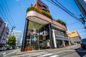 a building on the corner of a city street at Emblem Hostel Nishiarai in Tokyo