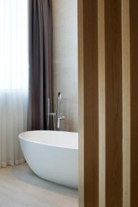 a white tub in a bathroom with a window at Hotel Terme Neroniane in Montegrotto Terme