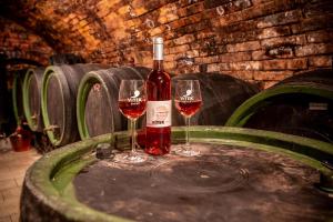due bicchieri di vino rosso appoggiati su una botte di Apartmán Marie a Mutěnice