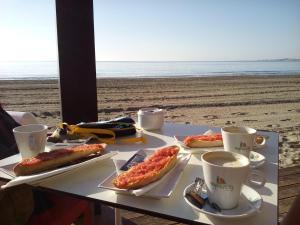 a table with hot dogs and cups of coffee on the beach at Casa Pelican in Orihuela Costa
