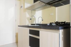 a kitchen with a sink and a stove at Clean Studio Apartment Connected to Mall at Orchard Supermall Mansion By Travelio in Surabaya