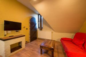 a living room with a red couch and a tv at City Flats by Lybeer Hotel Group in Bruges