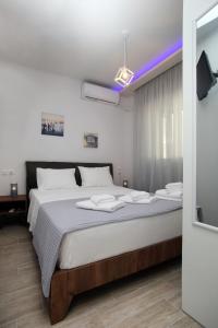 a bedroom with a large bed with white sheets at SunsetPeramos in Néa Péramos