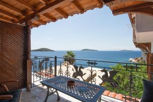 uma varanda com uma mesa e vista para o oceano em ClubOrsa Chrysoula's Guest House em Skiathos