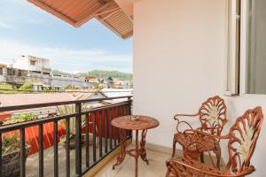 een balkon met 2 stoelen, een tafel en een raam bij RedDoorz near Jembatan Siti Nurbaya Padang in Padang
