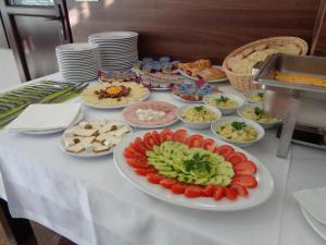 a table with plates of food on a table at Apartmani Lux Novalić in Konjic
