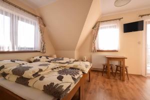 1 dormitorio con 2 camas y mesa en U Pawlikowskich, en Poronin