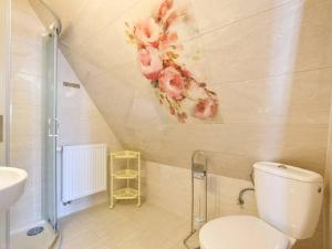 uma casa de banho com WC e flores na parede em U Pawlikowskich em Poronin