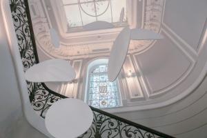 a staircase in a building with white ceilings and a window at Hôtel Vendôme in Nice
