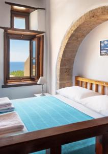 Un dormitorio con una cama grande y una ventana en Ypatia Cozy Castle Suite Apartment with Loft, en Monemvasia