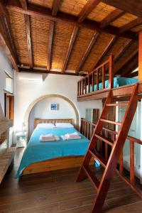 Ypatia Cozy Castle Suite Apartment with Loft في مونيمفاسيا: غرفة نوم مع سرير بطابقين مع سلم