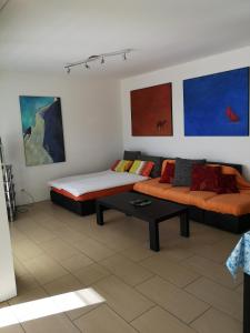 sala de estar con 2 camas y sofá en Attico Bellavista, en Locarno